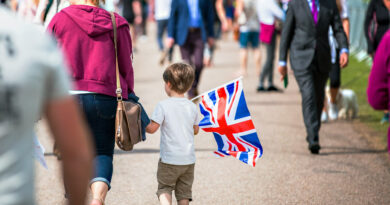 Child in a crowd with UK flag.